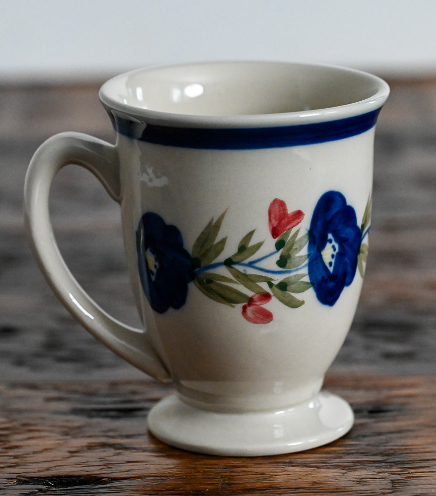 tan pedestal mug with blue and pink flowers