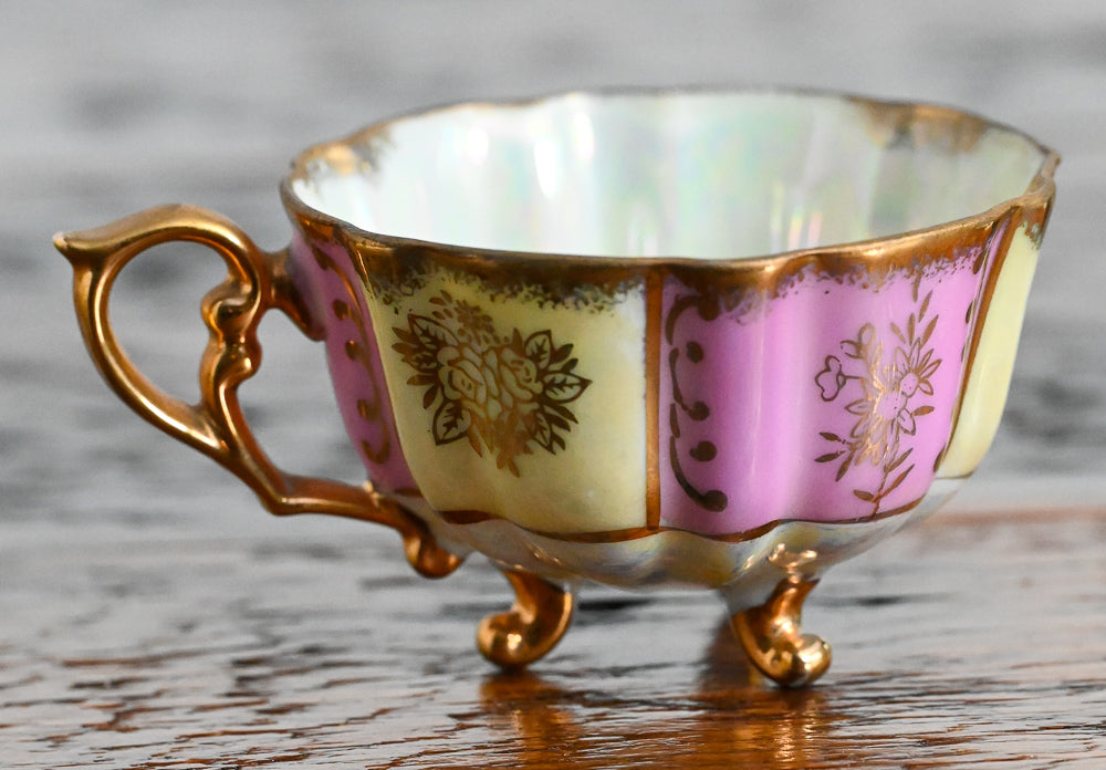 pink and cream teacup with gold handle, trim and legs