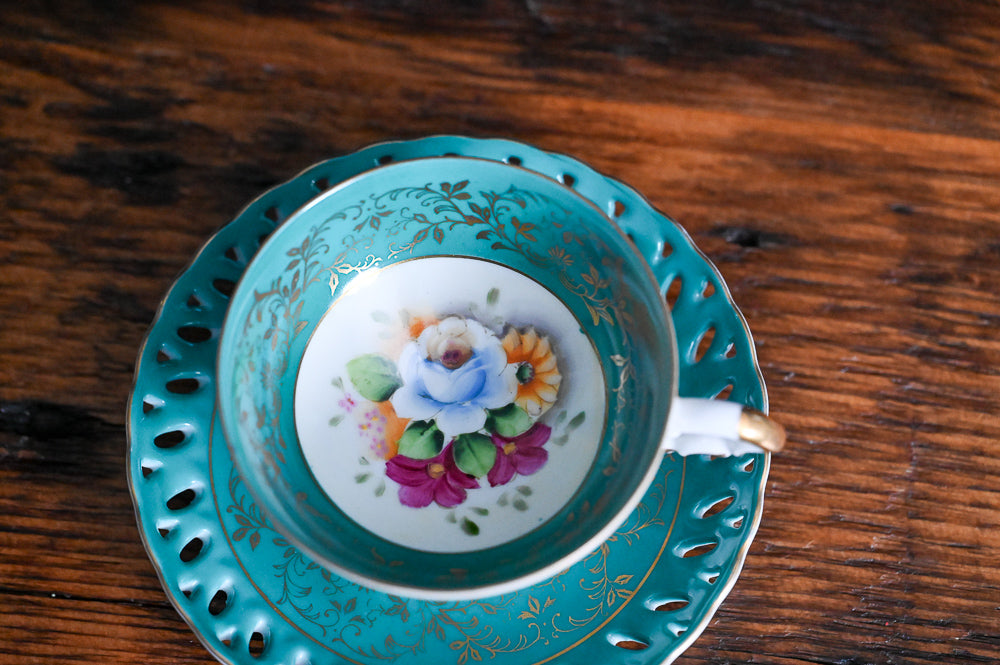 teal and white, gold floral Japanese Tea cup, colorful floral in bottom of cup