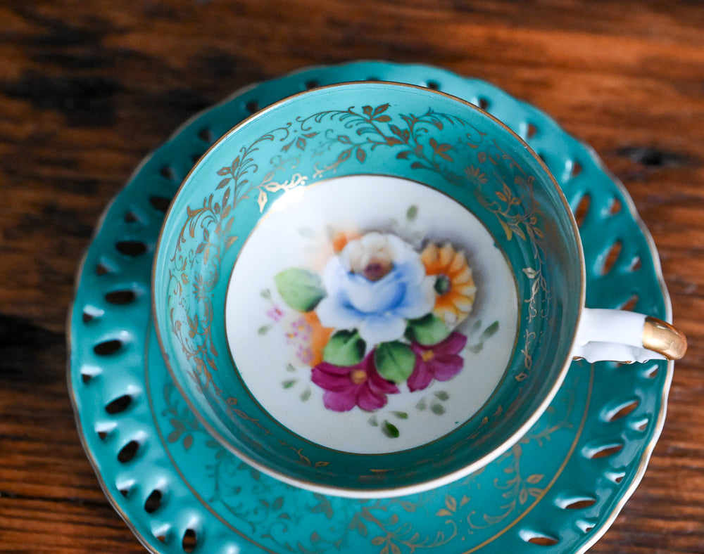 teal and white, gold floral Japanese Tea cup, colorful floral in bottom of cup