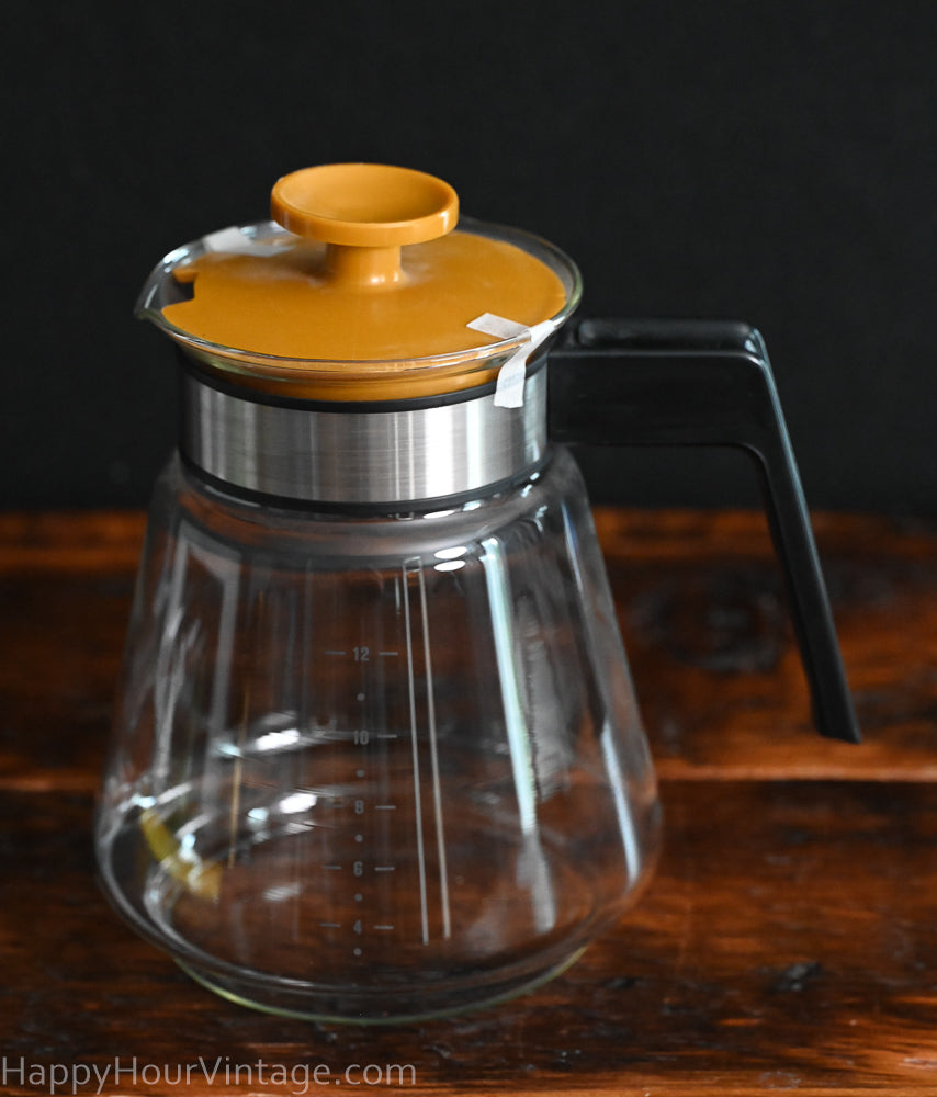 MCM coffee carafe with black handle and mustard color lid