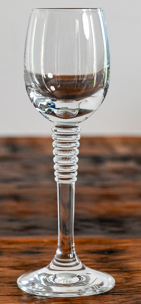 cordial glass with stacked stem on wood table