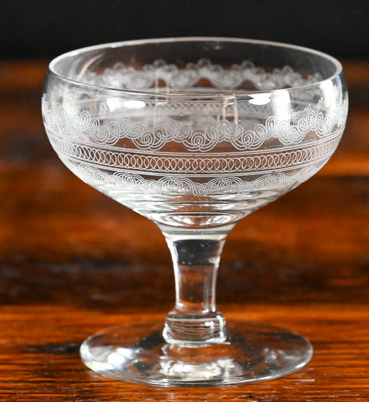 needle etched cocktail coupes on wood table