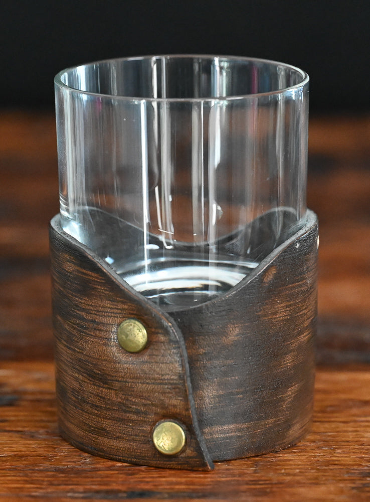 clear rocks glass sitting in leather holder 