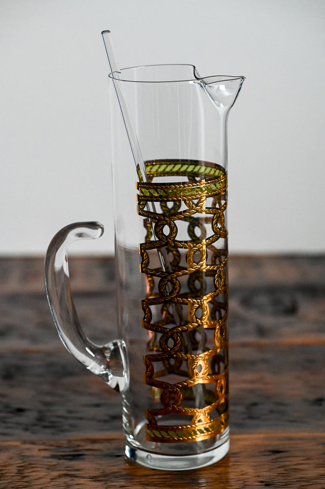 clear glass pitcher with gold and green accents