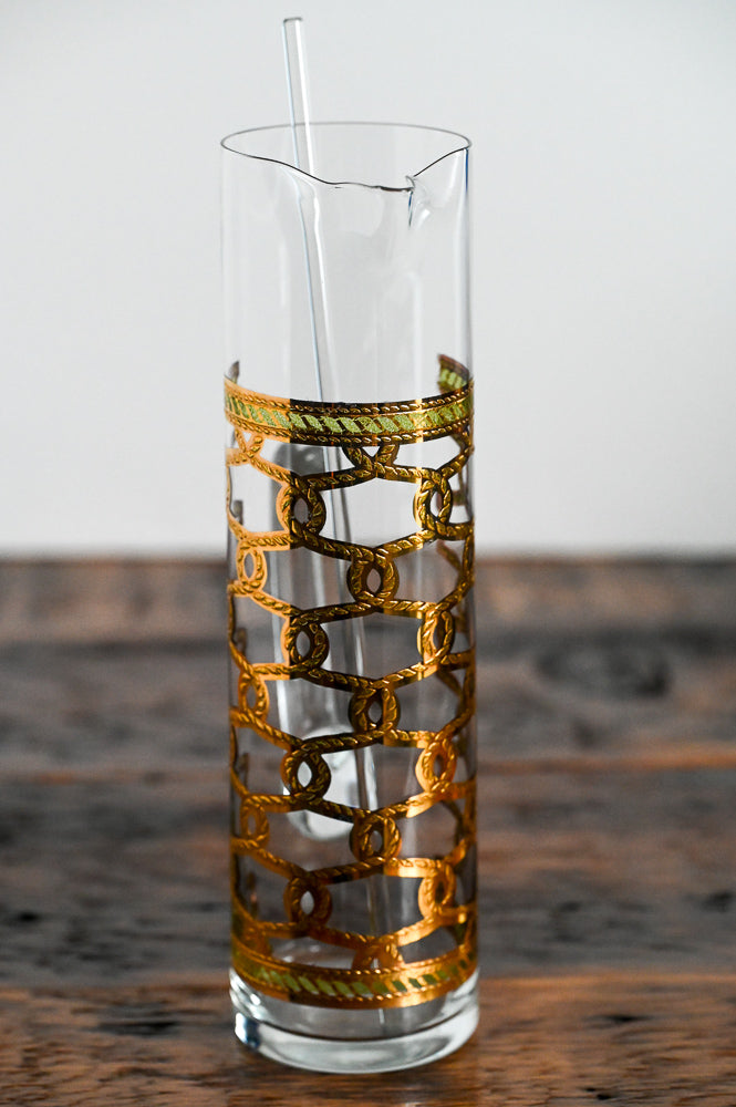 clear glass pitcher with gold and green accents