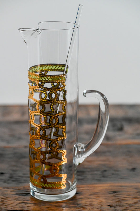 clear glass pitcher with gold and green accents