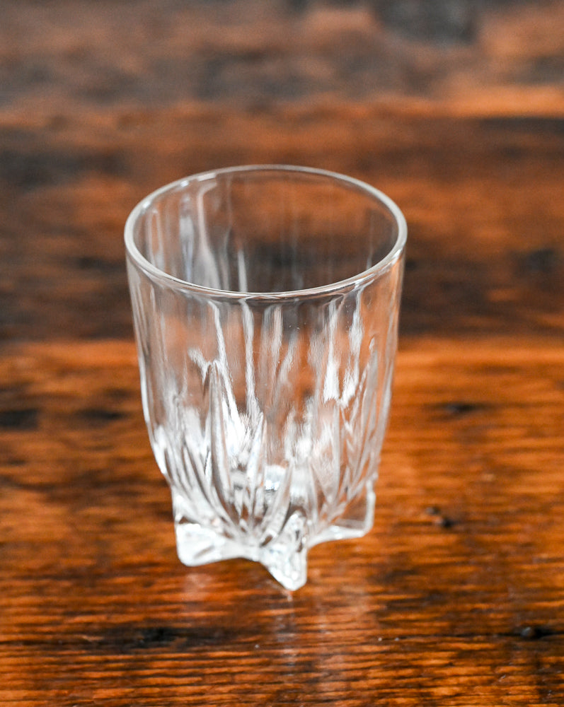 glass with small feet on wood table