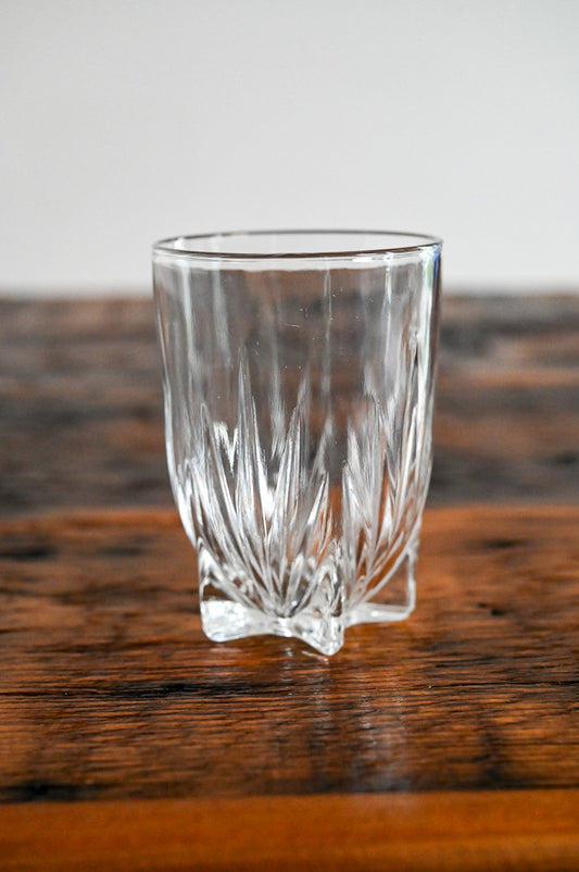 glass with small feet on wood table
