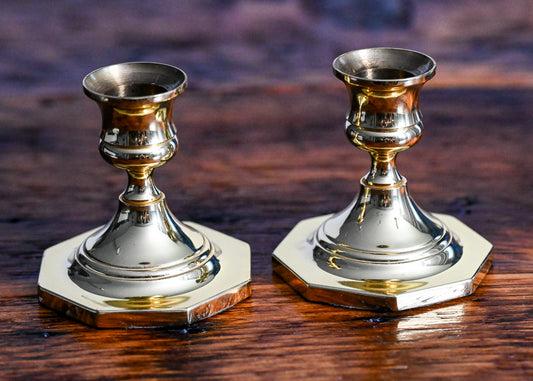 brass candlesticks on wood table